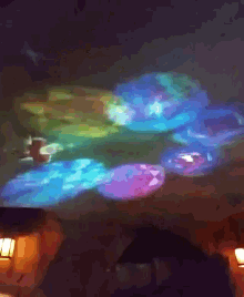 a colorful painting is projected on the ceiling of a dark room