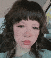 a close up of a woman 's face with earrings on