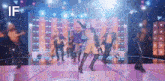 a group of people are dancing on a stage with the word if in the corner