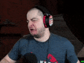 a man wearing headphones is making a funny face while talking into a microphone .