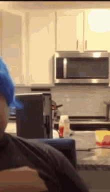 a man wearing a blue hat is in a kitchen