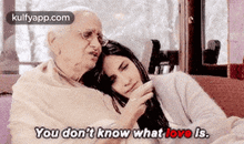an elderly man and a young woman are hugging each other on a bed .