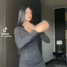 a woman in a black jacket is dancing with a tiktok watermark