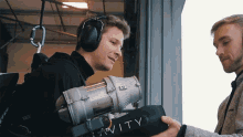 a man wearing headphones is holding a box that says gravity