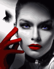 a black and white photo of a woman with red lipstick and blue eyes