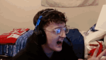 a man wearing headphones and glasses is making a face