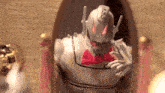 a statue of a robot with a bow tie is sitting in front of a mirror .