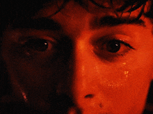 a close up of a person 's face with a red and blue background