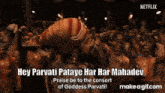 a man is standing in front of a crowd with his hands in the air and says hey parvati pataye har har mahadev