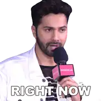 a man with a beard is holding a microphone that says right now