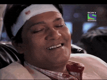 a man with a bandage on his head is smiling in front of a sony television logo