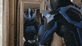 a person in a superhero costume is standing in front of a mirror .