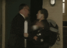a blurry picture of a man in a suit walking through a door .