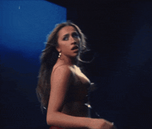 a woman in a red bra stands in front of a blue background