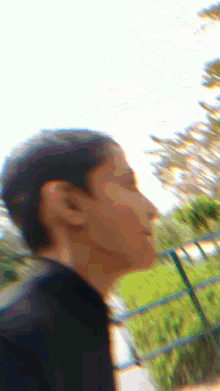 a blurry picture of a person 's face with a fence in the background