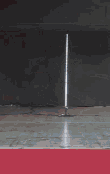 a woman is standing on a red carpet holding a sword in her hand .