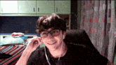 a young man wearing glasses and earbuds is smiling
