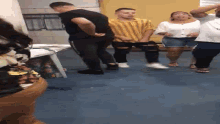 a group of people are standing in a room dancing .