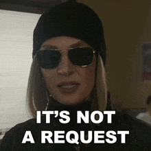 a woman wearing sunglasses and a hat says " it 's not a request "
