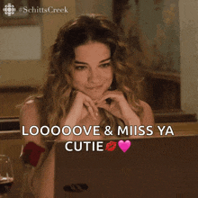 a woman is sitting in front of a laptop with the words loooove & miss ya cutie boop