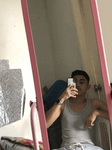 a man is taking a selfie in front of a mirror with a pink frame