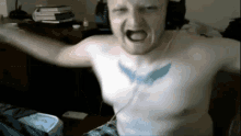 a shirtless man with a tattoo on his chest is screaming
