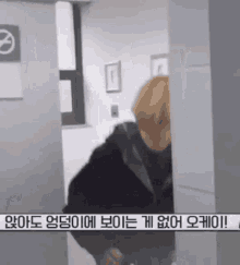 a man is standing in a room with a no smoking sign on the wall .
