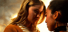 two women are looking at each other with their eyes closed .
