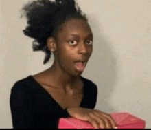 a woman with a surprised look on her face is holding a pink box