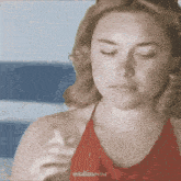 a woman in a red top is smoking a cigarette