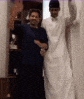 two men are standing next to each other in a room and dancing .