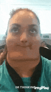 a woman is making a funny face with her mouth wide open and looking up .