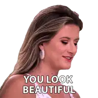 a woman is smiling with the words you look beautiful behind her