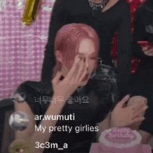a woman with pink hair is covering her face in front of a birthday cake