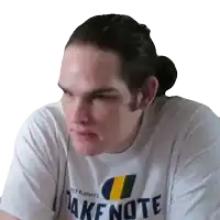 a man wearing a white shirt that says take note on it