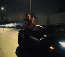 a man in a red jacket is sitting in the back of a car