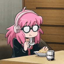 a girl with pink hair and headphones is sitting at a table
