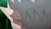 a close up of a person holding a gray object with the letter m written on it