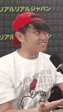a man wearing a red hat and a white shirt that says go