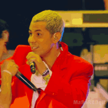 a man in a red jacket is singing into a microphone with the word mafia on the bottom