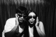 a man and a woman wearing sunglasses pose for a photo
