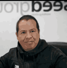 a man is wearing a black nike jacket