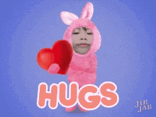 a girl in a pink bunny costume is holding a red heart in her hands