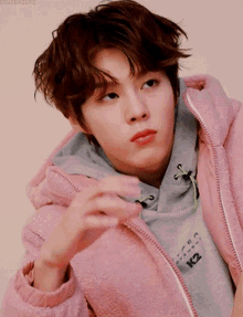 a young man wearing a pink jacket that says k2 on the front