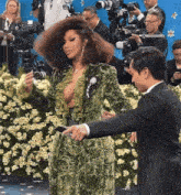 a woman in a green dress is being photographed by a man in a tuxedo
