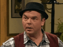 a man wearing a black hat and a plaid shirt