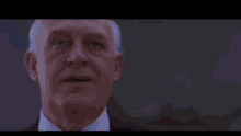 a person is standing in a dark room next to a window with a blue light shining through it .