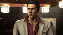 a man in a suit and a red shirt is standing in a room