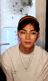 a man wearing glasses and a white shirt with the word smile on the front