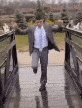 a man in a suit is jumping over a bridge .
